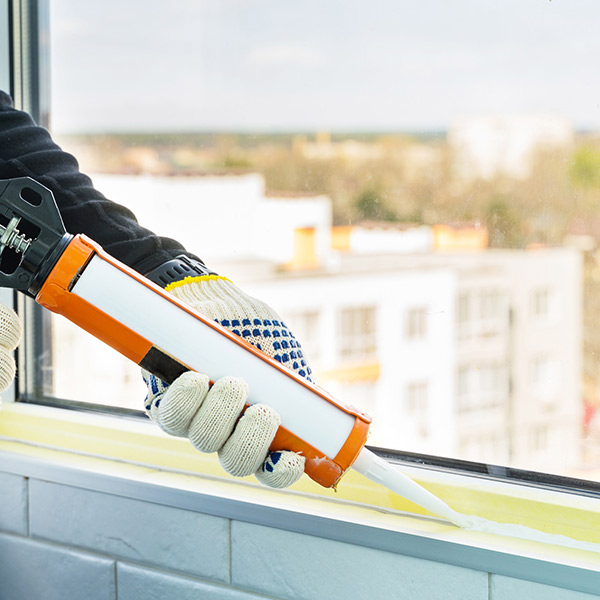 man applying white cement in gaps